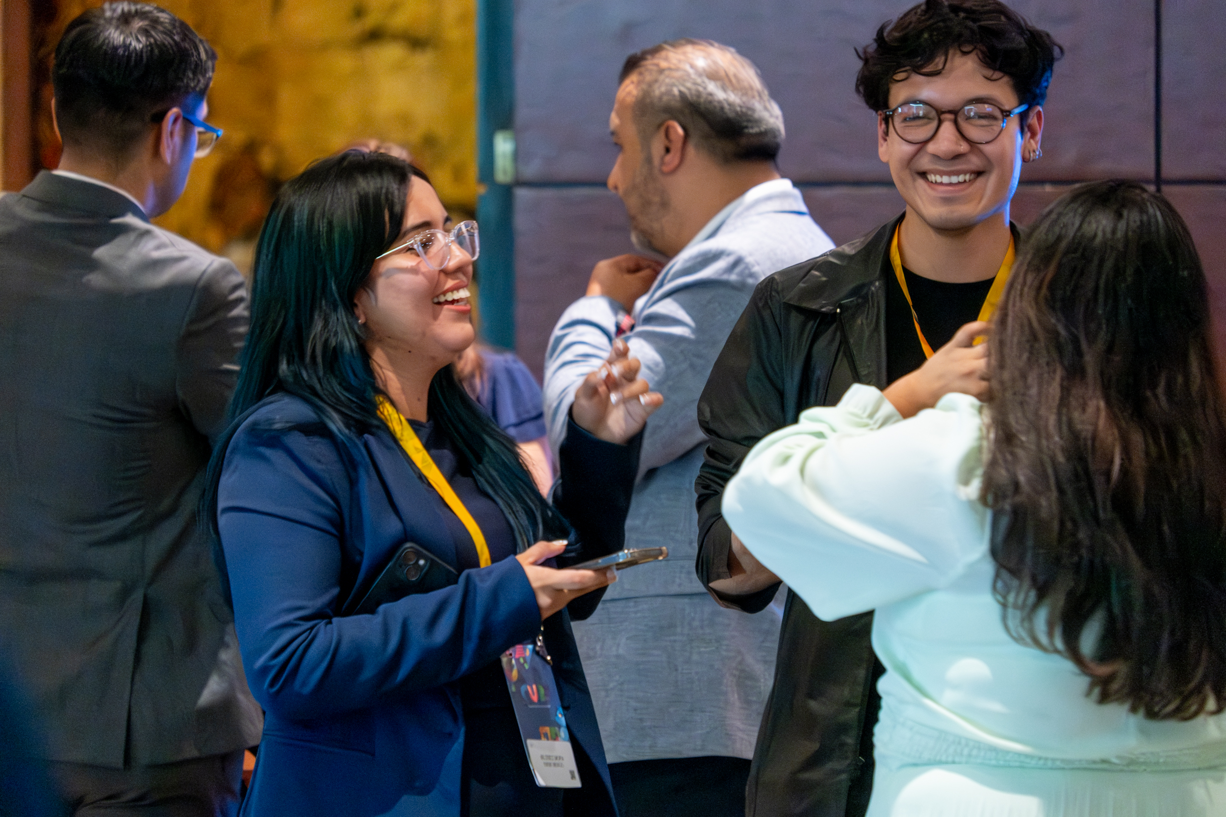 Three people standing togetjer at a trade show, looking at a tablet one of them is holding