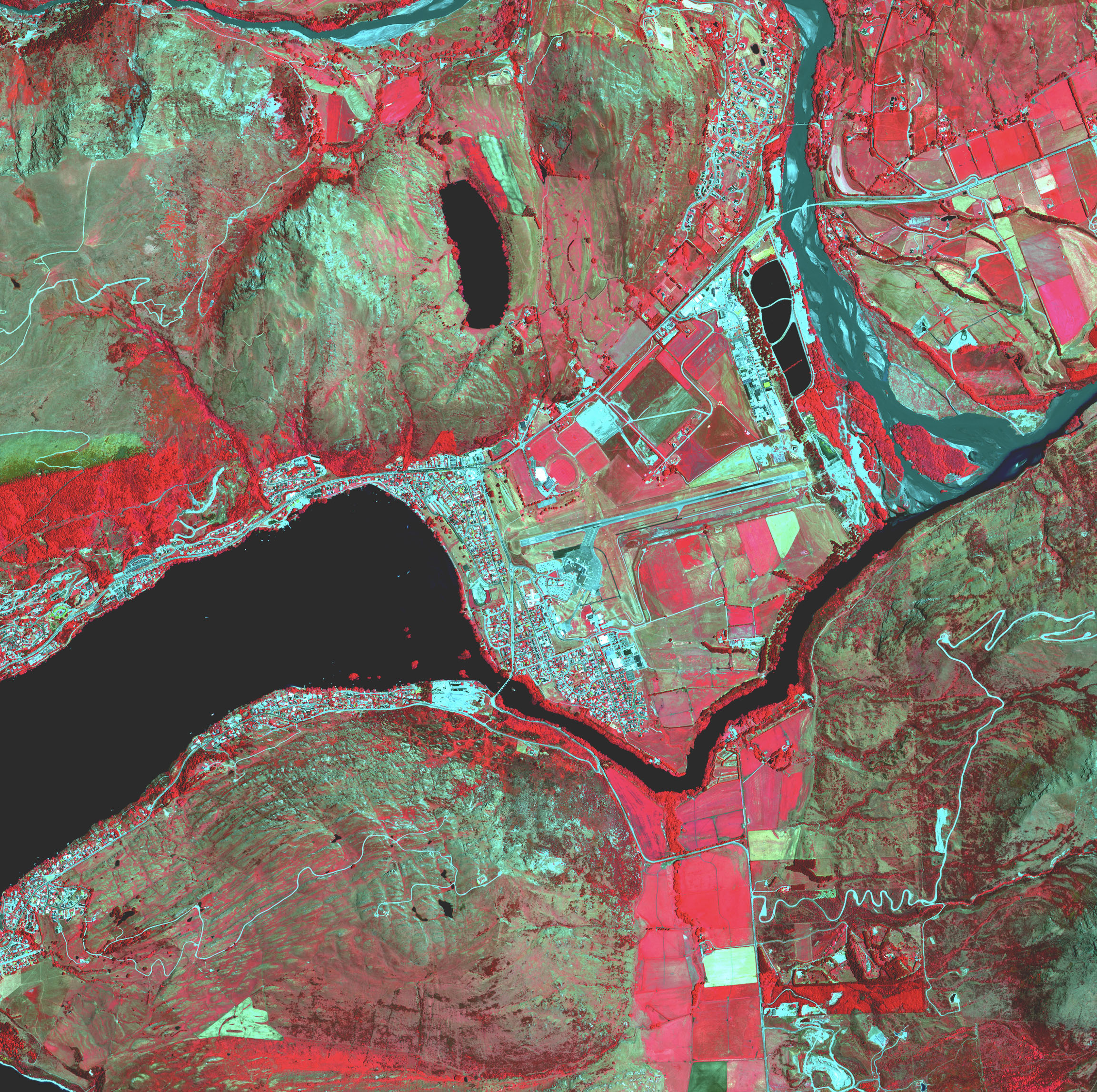 Un mapa de una ciudad junto a un río muestra puntos calientes y campos de cultivo en tonos de rojo.