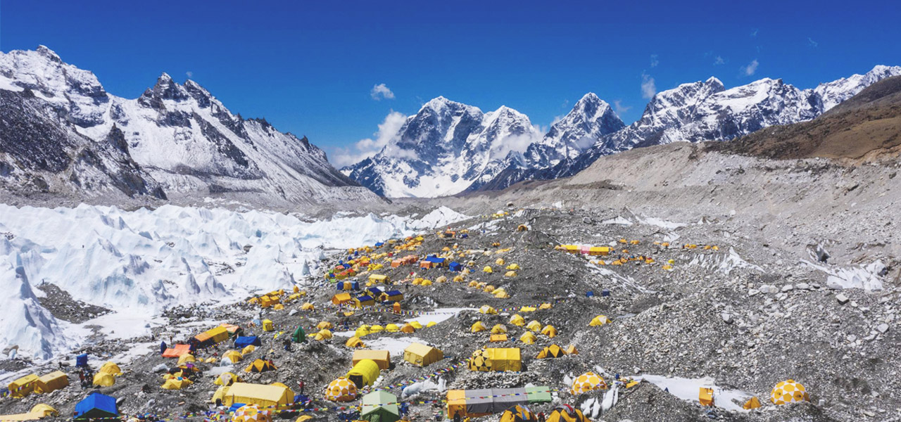 Imágenes de un dron muestran el campamento base del monte Everest lleno de tiendas de campaña amarillas y azules, rodeado de montañas nevadas