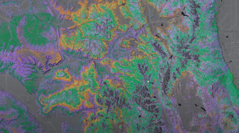 Una imagen por satélite de un paisaje boscoso muestra datos de la cubierta terrestre obtenidos por teledetección en un gradiente púrpura, naranja y verde