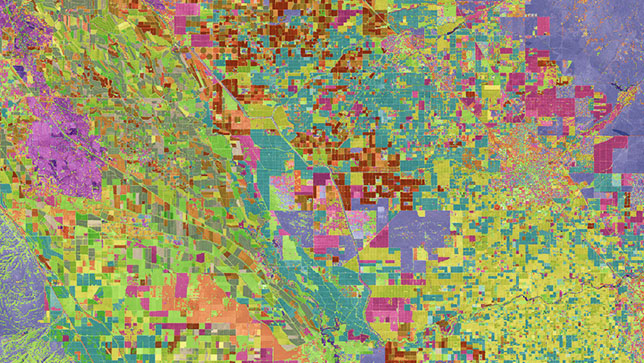 Una imagen aérea azul, verde, roja y rosa en que se identifican parcelas de tierra 