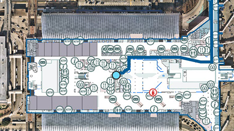 Mapa del interior de una instalación aeroportuaria que muestra el punto azul de la ubicación actual y puntos de datos redondos dispersos en una vista aérea