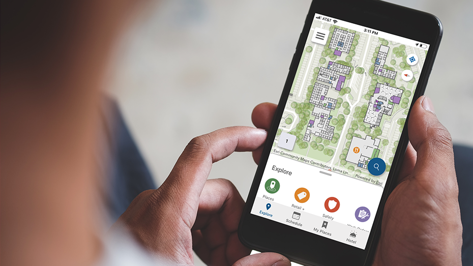 Persona mirando un mapa de interiores del edificio de oficinas en un teléfono móvil