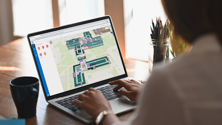 Persona trabajando con ArcGIS Indoors desde casa en un portátil para revisar la utilización del espacio en un mapa de interiores