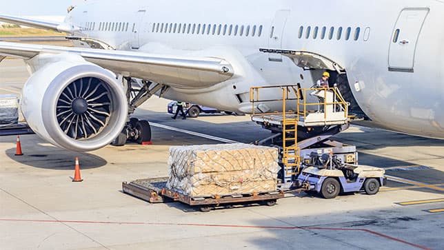 Un trabajador descargando un gran envío de un avión