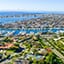 Vista gran angular desde arriba de un barrio costero con una dársena para embarcaciones y muchos barcos atracados o fondeados.