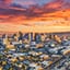 Vista aérea de Phoenix, Arizona, al atardecer, iluminada por una cálida luz anaranjada sobre un cielo radiante