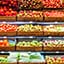 Cestas de mimbre con frutas y verduras expuestas en una tienda