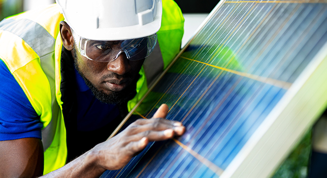 Un trabajador de campo comprueba con la mano la instalación de un panel solar