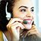 A photo of a row of three smiling people speaking into headsets in a brightly lit room