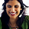 A photo of a smiling person in a vivid green shirt wearing a headset against a blurred white background