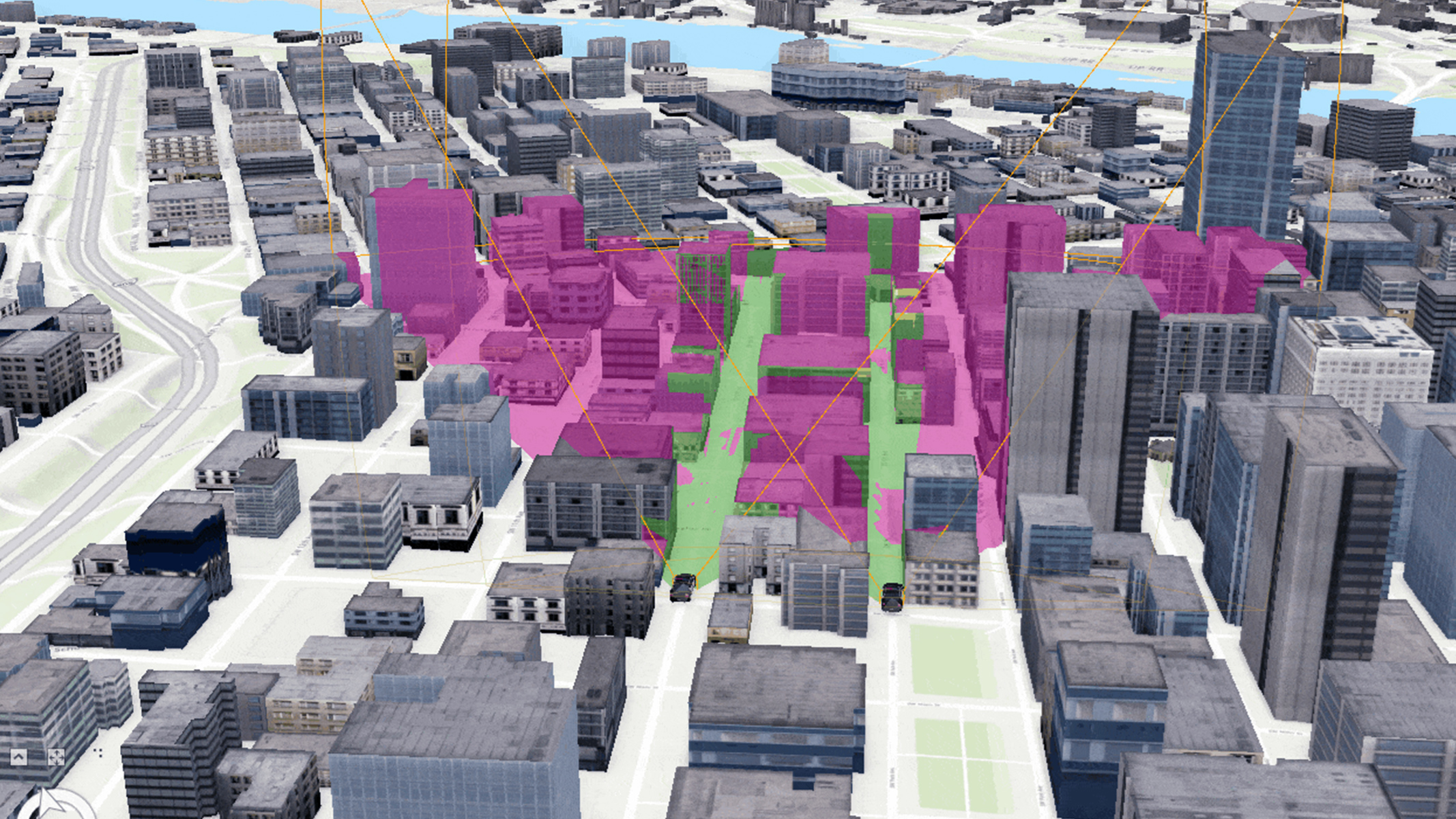 Modelo 3D del centro de una ciudad. Varios edificios aparecen resaltados en tonos rosas y verdes, indicando zonas o áreas de interés dentro de la ciudad.